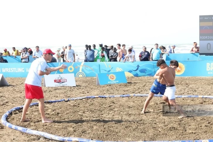 Acción durante un combate internacional de lucha de playa